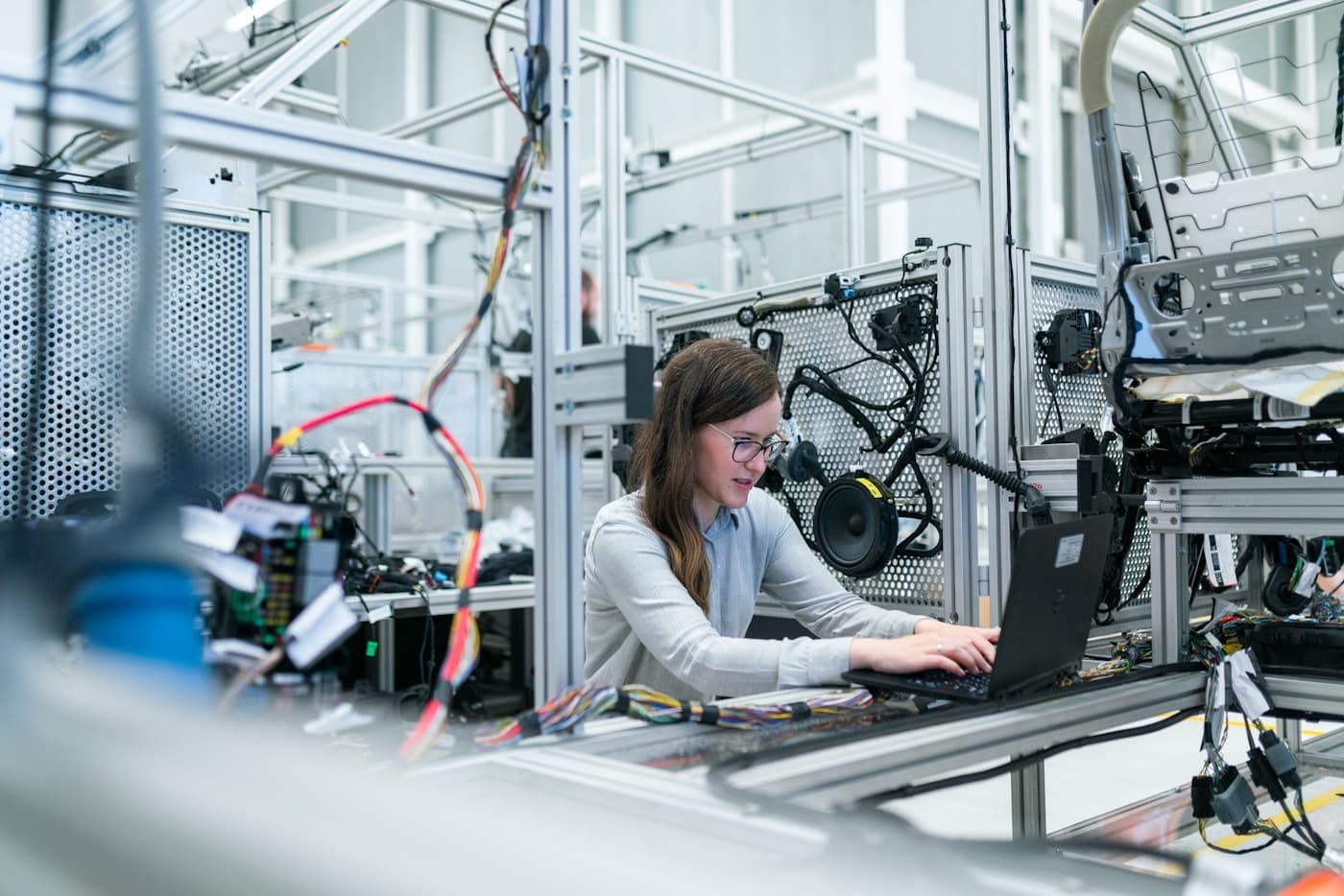 Industrial factory floor with production line and quality-control monitoring interface, editorial context image