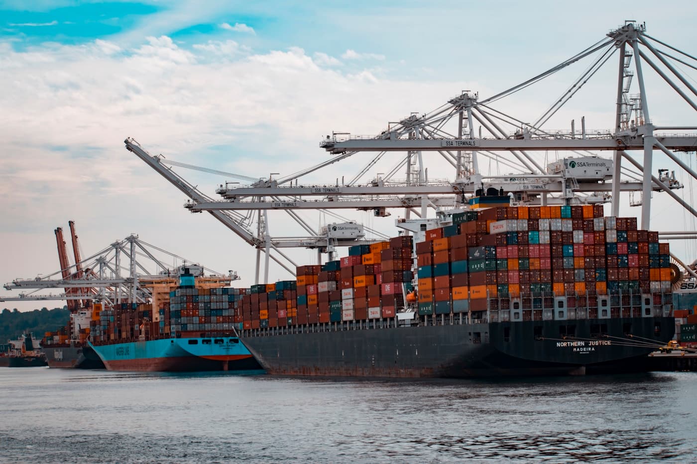 International trade operations desk with supplier comparison, shipping documents and logistics visibility, editorial context image
