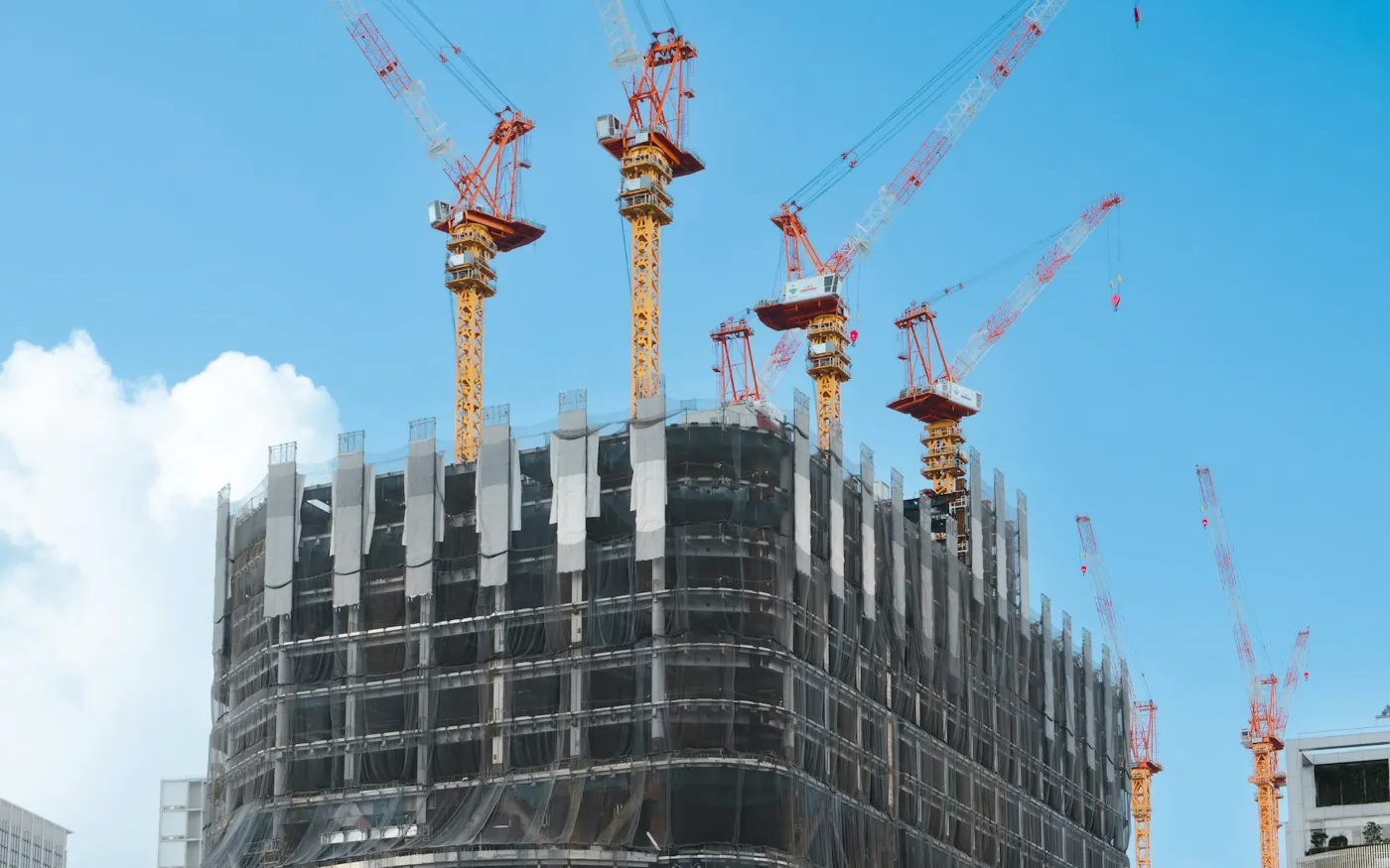 Large construction site with tower cranes and safety perimeter
